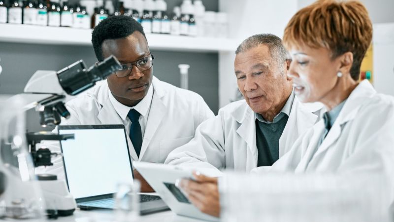 Three-person research team viewing something on a tablet