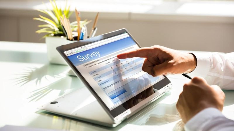 Man pointing at survey information on a laptop screen