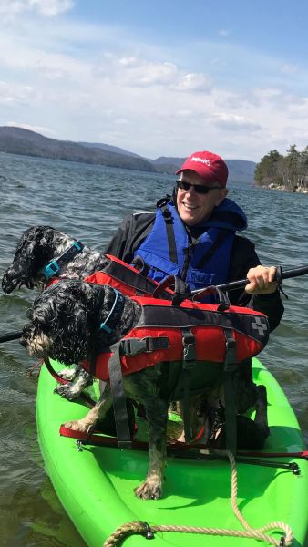 Man kayaking with dogs