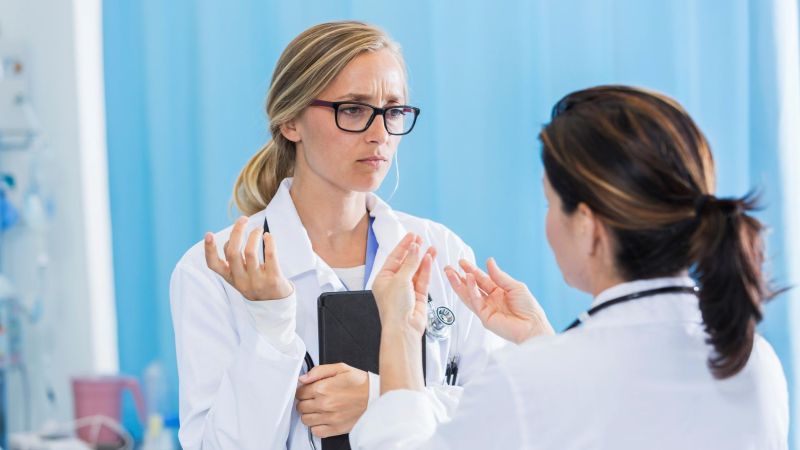 Two medical professionals are having a discussion